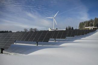 Solar panels and wind turbine in snow